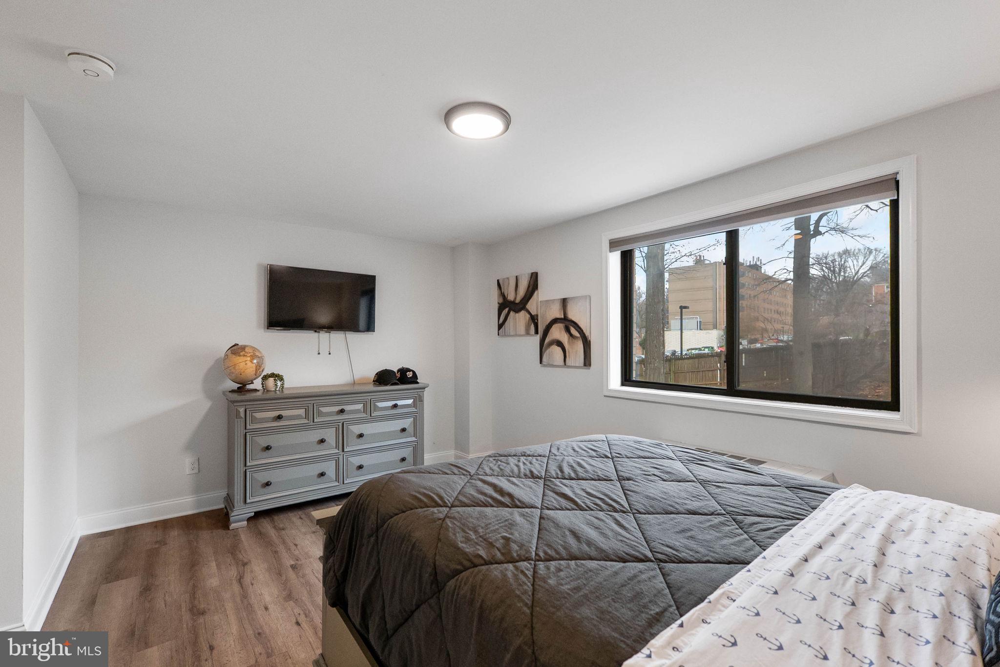 8601 Manchester Road, Unit 220 Silver Spring, MD 20901 - Photo 21 of 27 a bedroom with a bed and a flat tv screen on dresser