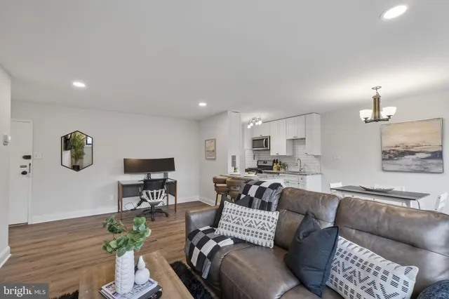 a living room with furniture kitchen view and a table