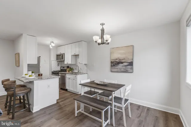 a kitchen with a dining table chairs stove and cabinets