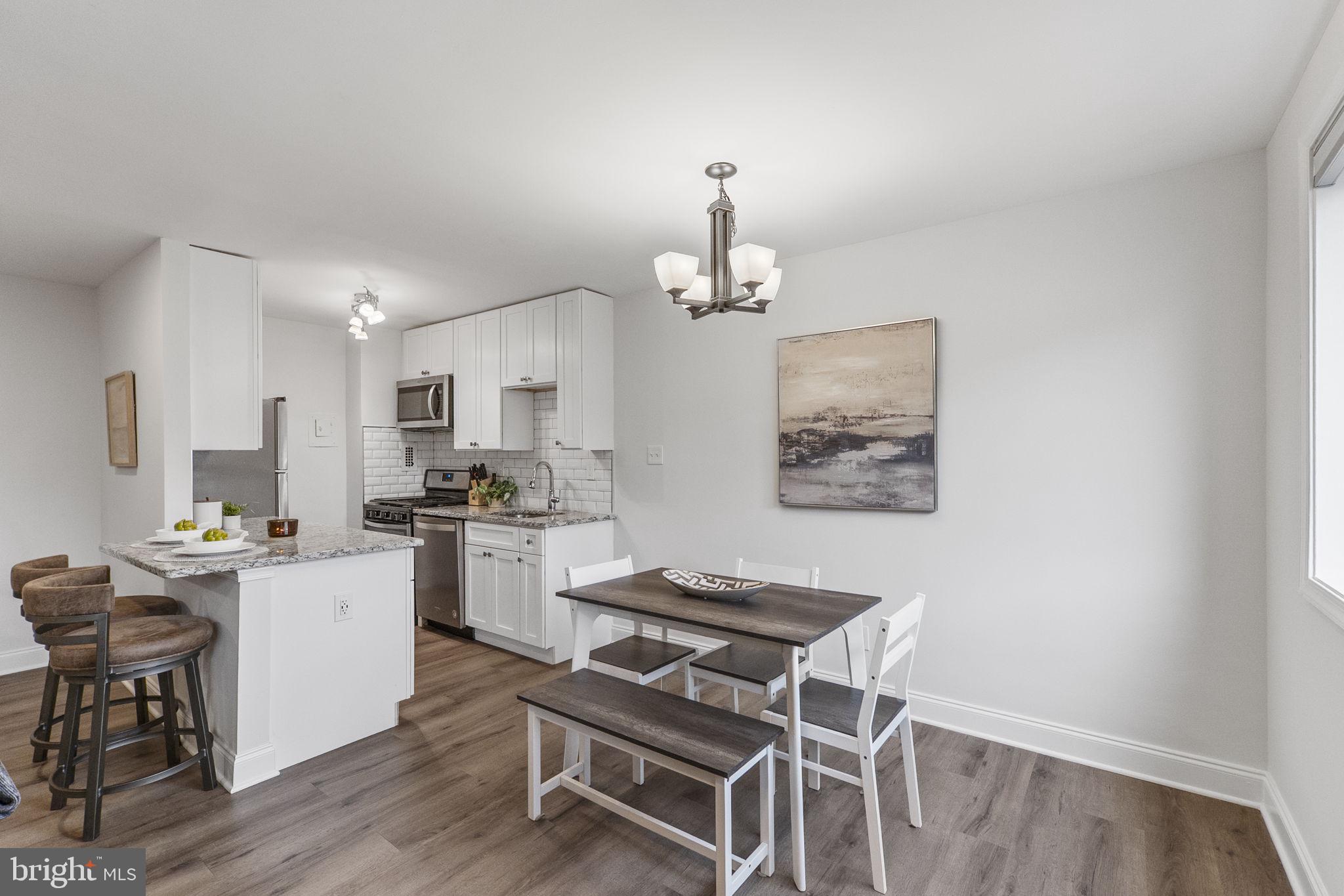 8601 Manchester Road, Unit 220 Silver Spring, MD 20901 - Photo 6 of 27 a kitchen with a dining table chairs stove and cabinets