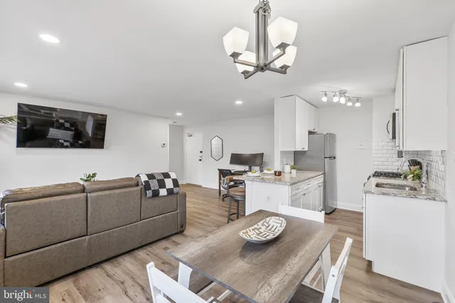 a living room with furniture kitchen and a chandelier