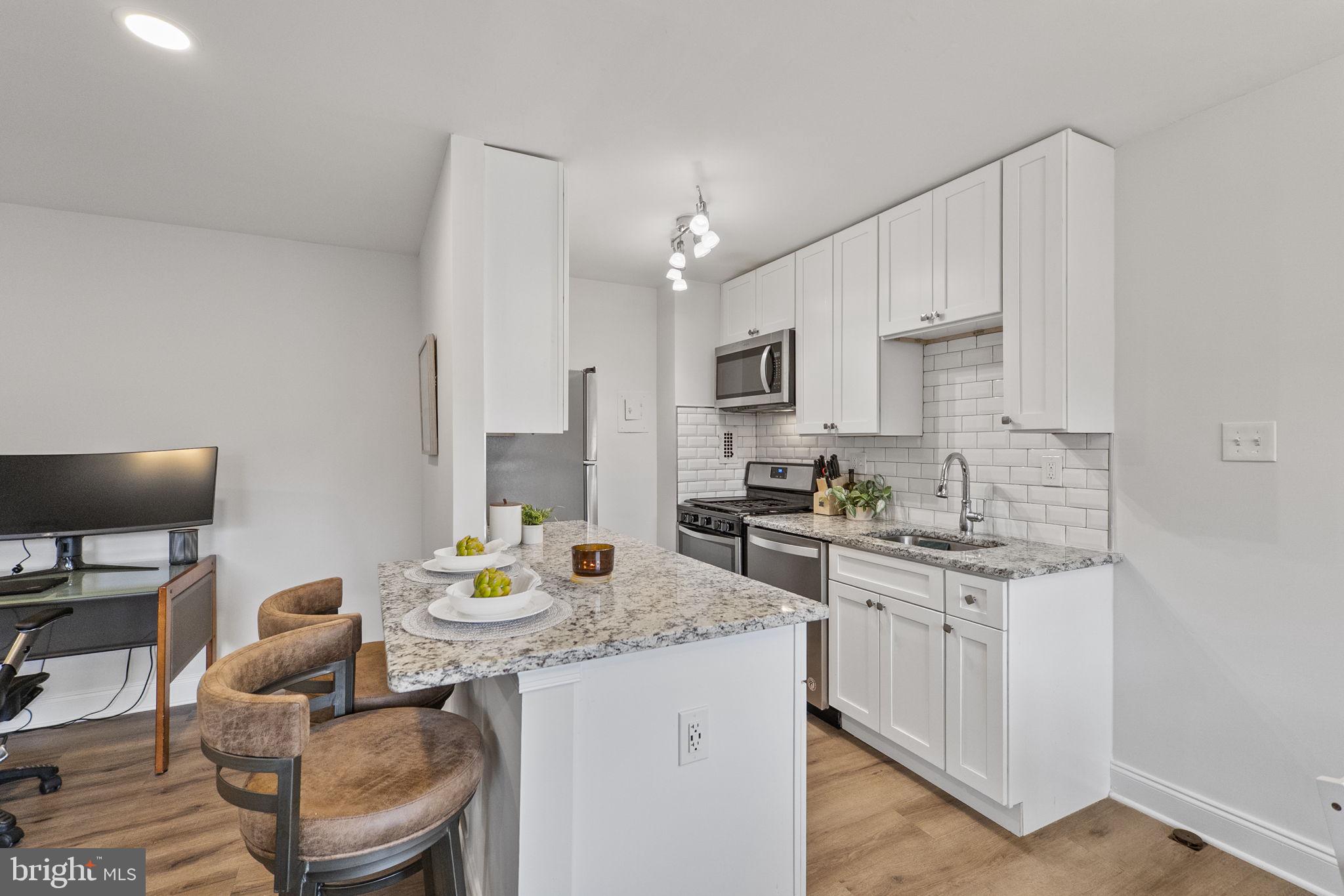 8601 Manchester Road, Unit 220 Silver Spring, MD 20901 - Photo 9 of 27 a kitchen with a sink stove top oven and microwave