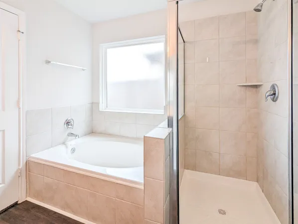 a white bath tub sitting next to a shower