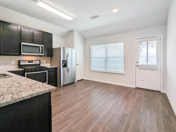 a kitchen with granite countertop a refrigerator and a sink
