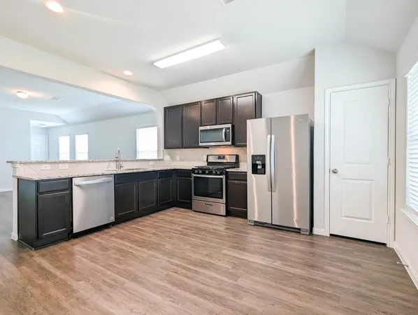 a large kitchen with a refrigerator and a sink