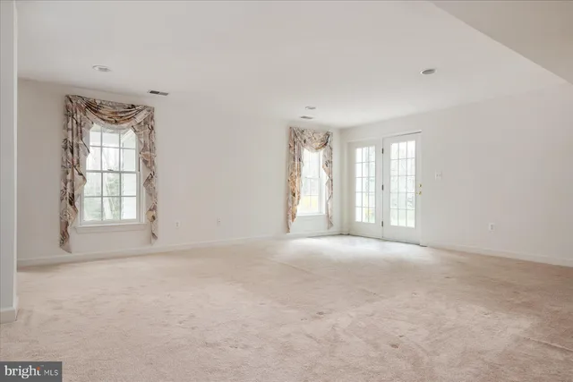 a front view of a house with garden and trees