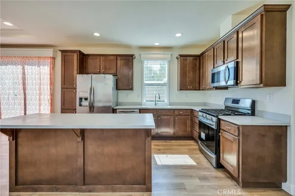a kitchen with stainless steel appliances granite countertop a stove a sink and a refrigerator