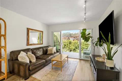 a living room with furniture a flat screen tv and a large window