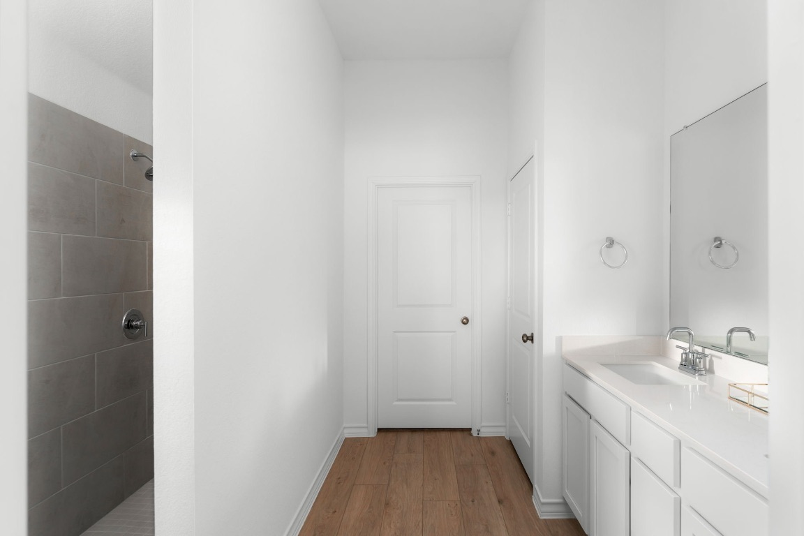 4264 Hill House Lane Georgetown, TX 78628 - Photo 15 of 30 Full bathroom with a tile shower, light wood-type flooring, and vanity