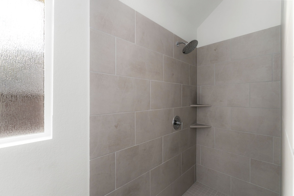 4264 Hill House Lane Georgetown, TX 78628 - Photo 16 of 30 Bathroom featuring a tile shower and vaulted ceiling