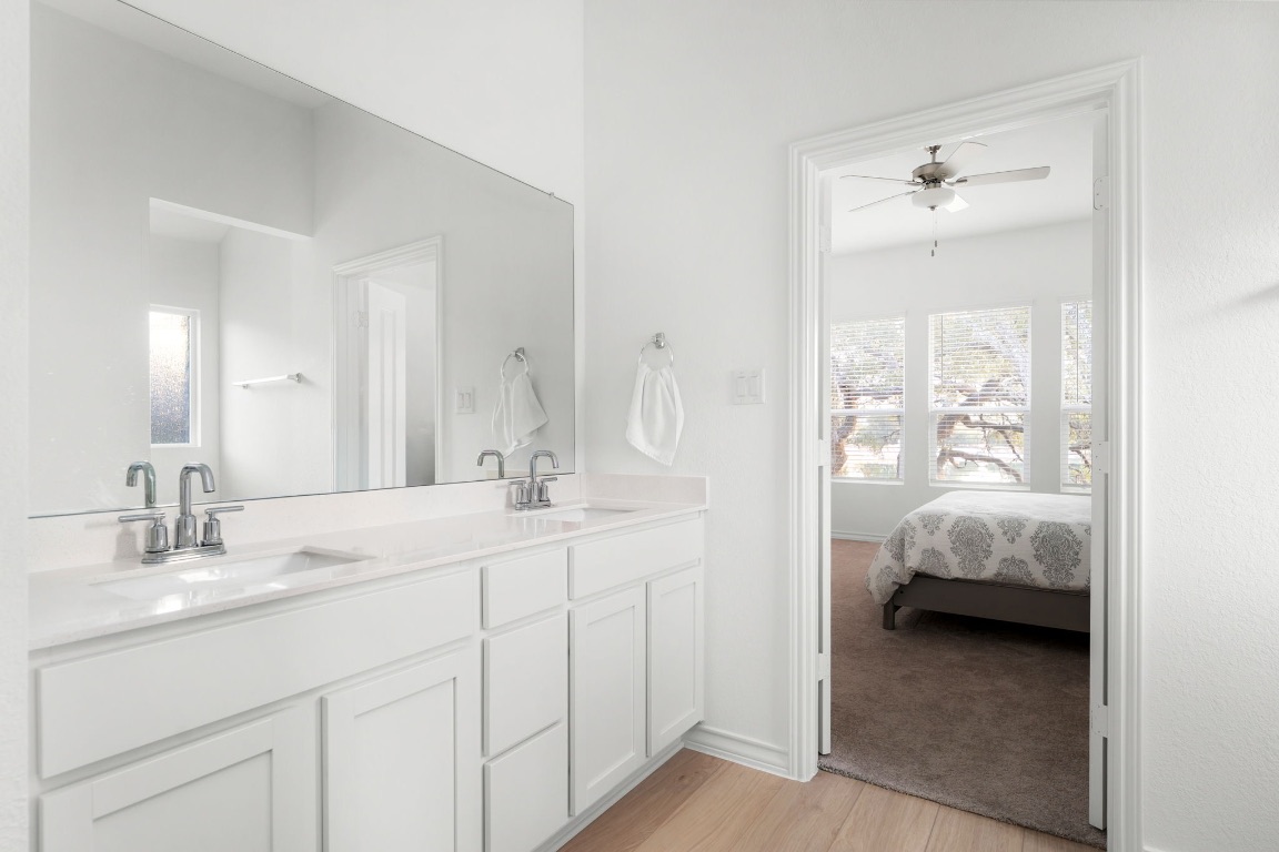 4264 Hill House Lane Georgetown, TX 78628 - Photo 18 of 30 Bathroom with double vanity, light wood-style floors, ensuite bathroom, and ceiling fan