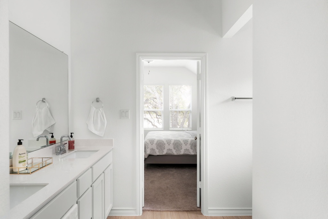 4264 Hill House Lane Georgetown, TX 78628 - Photo 19 of 30 Full bathroom with connected bathroom, double vanity, and light wood-style flooring