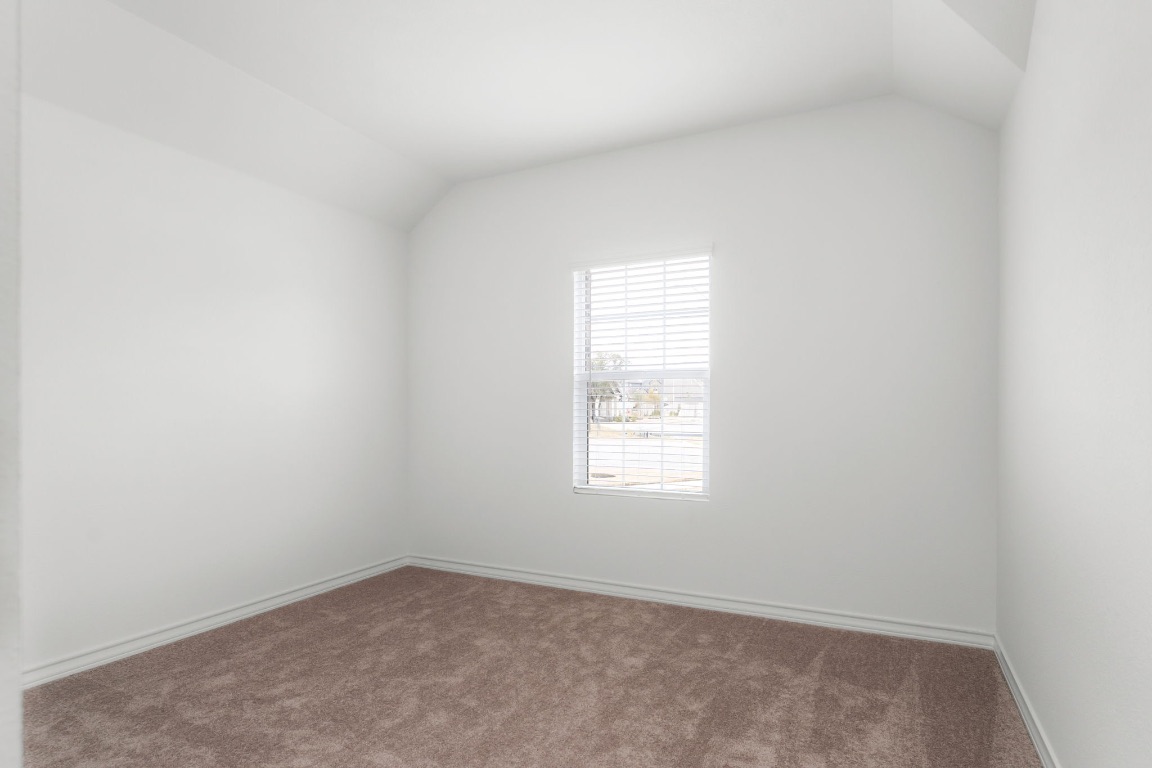 4264 Hill House Lane Georgetown, TX 78628 - Photo 21 of 30 Carpeted spare room featuring vaulted ceiling