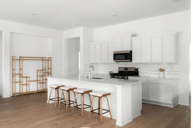 a kitchen with white cabinets and stainless steel appliances