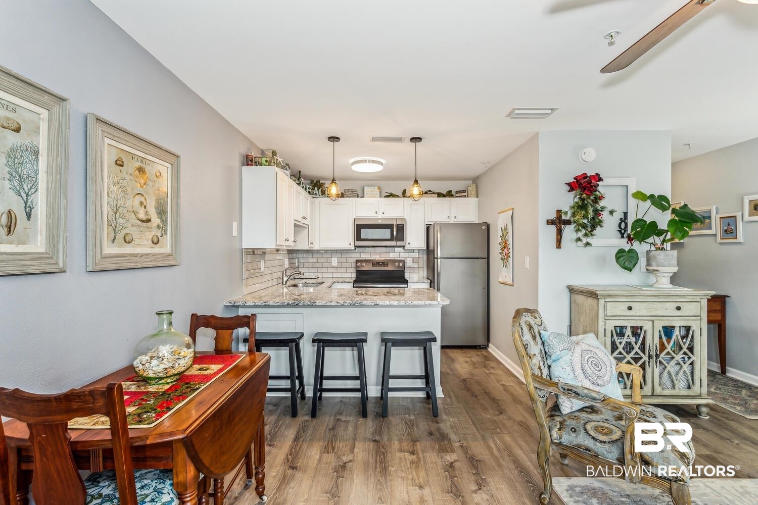 13551 Johnson Beach Road, Unit 112E Pensacola, FL 32507 - Photo 11 of 42 Kitchen with white cabinetry, stainless steel appliances, tasteful backsplash, kitchen peninsula, and light stone counters