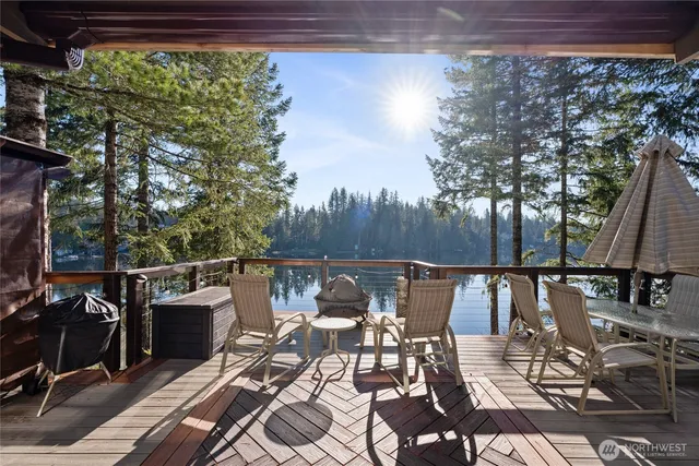 a view of deck with seating area and trees around