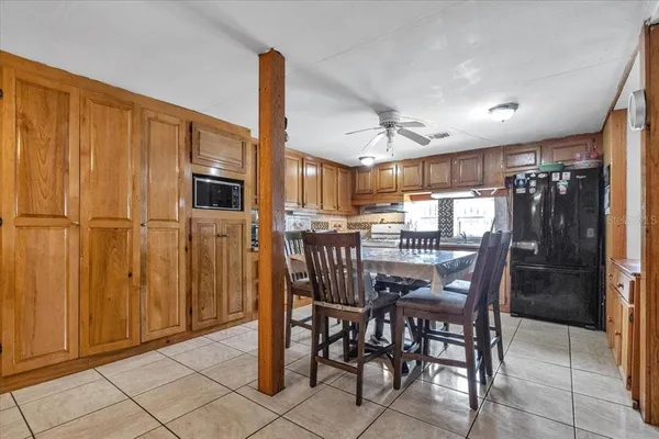 a kitchen with stainless steel appliances kitchen island granite countertop a table chairs and a refrigerator