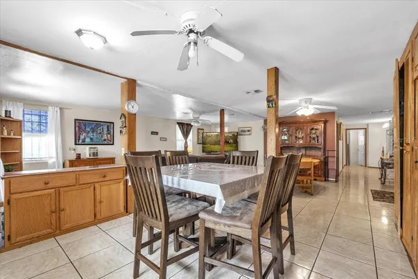 a dining hall with a dining table and chairs with the view of kitchen