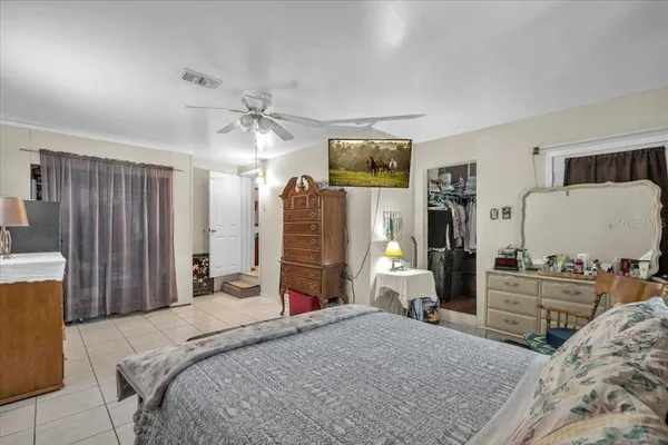 a bedroom with a bed table chair and a window