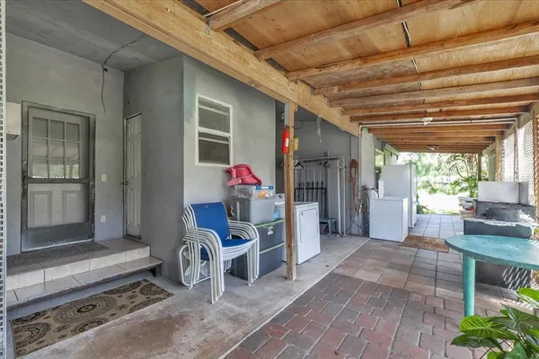 a view of a chair and tables in the patio next to a yard