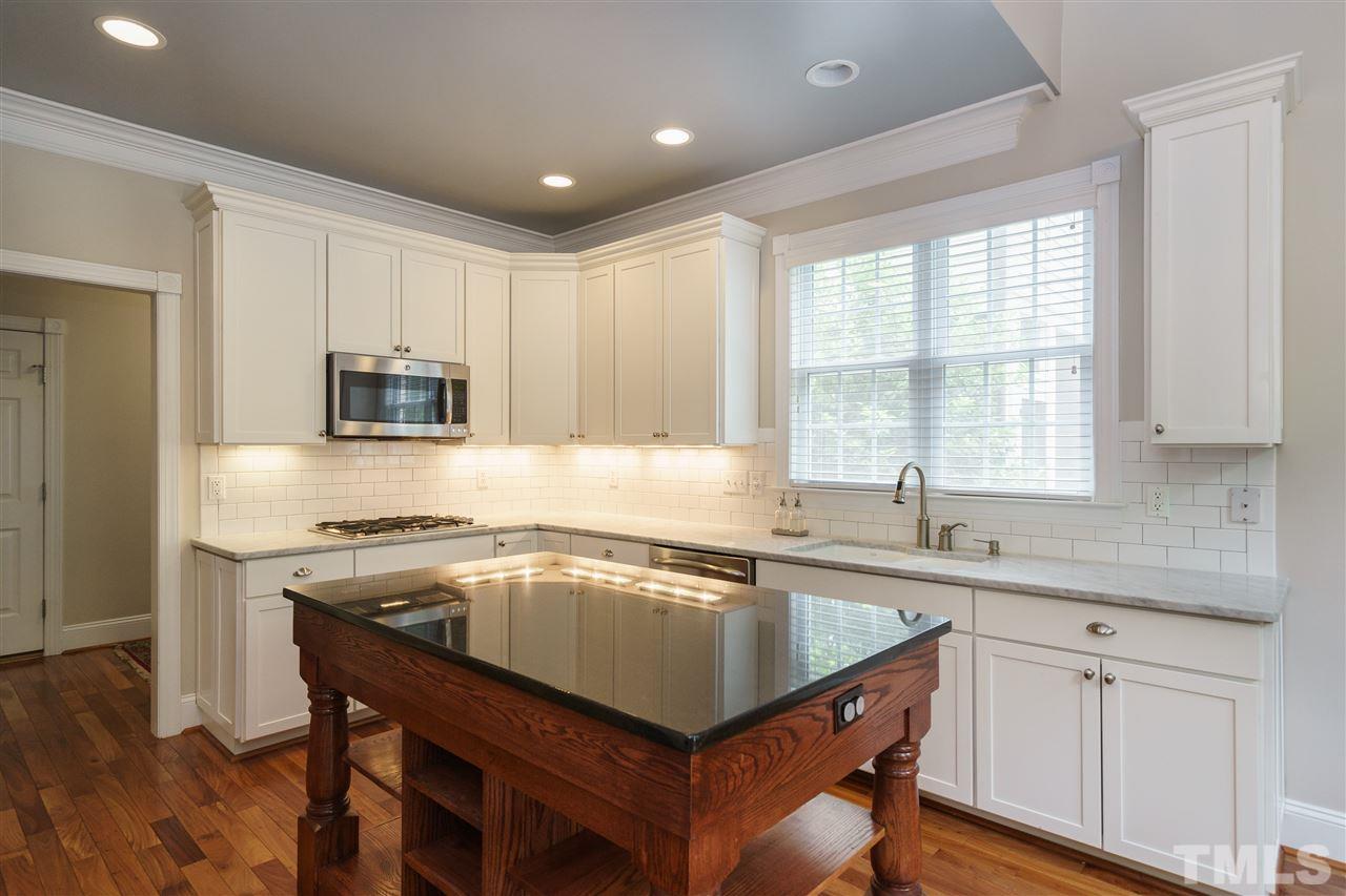 1117 Hobson Court Raleigh, NC 27607 - Photo 11 of 25 a kitchen with a stove a sink a microwave and wooden cabinets