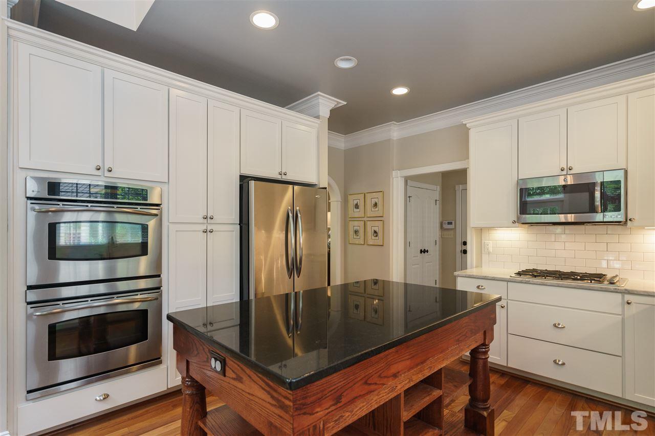 1117 Hobson Court Raleigh, NC 27607 - Photo 12 of 25 a kitchen with granite countertop a refrigerator stove and microwave