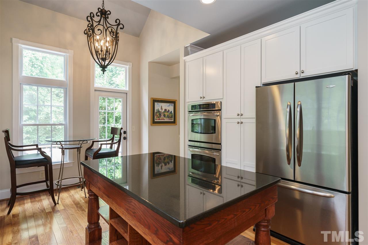 1117 Hobson Court Raleigh, NC 27607 - Photo 13 of 25 a kitchen with stainless steel appliances granite countertop a refrigerator a stove and a dining table with wooden floor