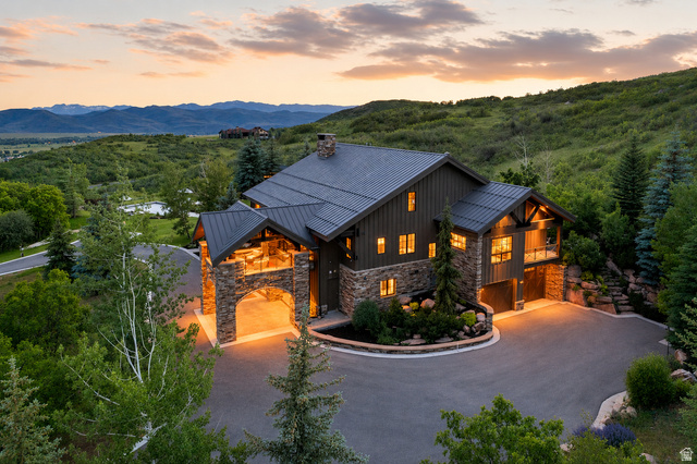 5971 Maple Ridge Trail Oakley, UT 84055 - Photo 39 of 43 Mountain contemporary residence featuring a stone and board-and-batten exterior, dark metal roof, and an arched porte-cochère