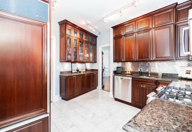 a kitchen with stainless steel appliances granite countertop a refrigerator and a stove top oven