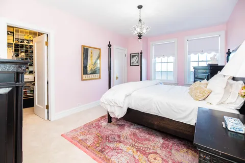 a bedroom with a bed wooden floor and window