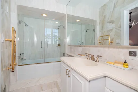 a bathroom with a sink shower and a mirror