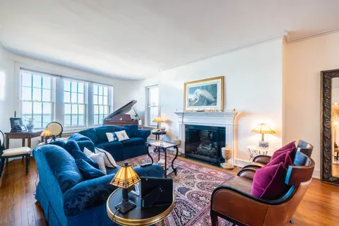 a living room with furniture a fireplace and a large window