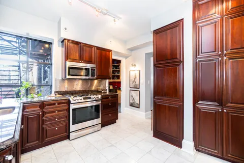 a kitchen with stainless steel appliances granite countertop a refrigerator and a stove top oven