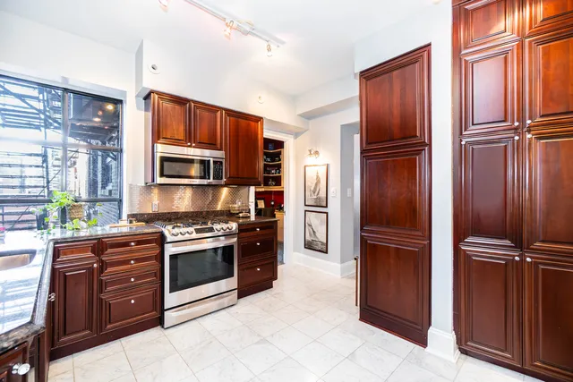 a kitchen with stainless steel appliances granite countertop a refrigerator and a stove top oven