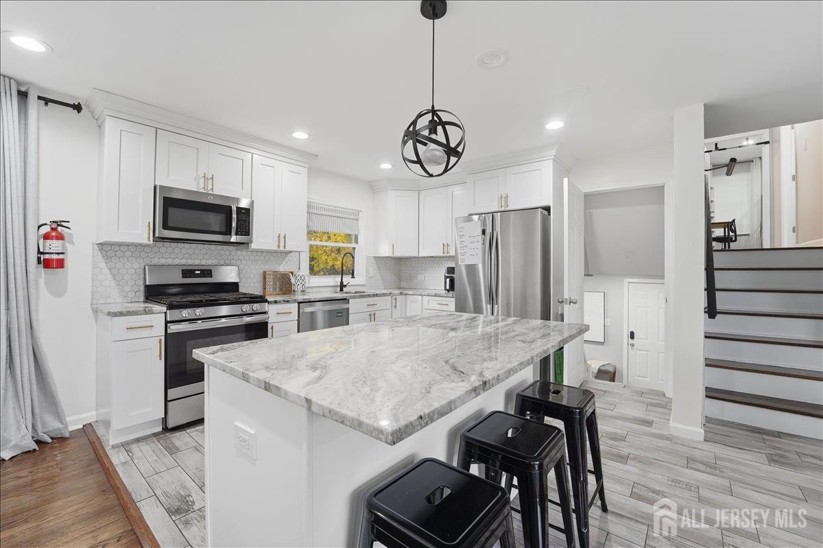 10 Maplehurst Lane Piscataway, NJ 08854 - Photo 9 of 28 a kitchen with stainless steel appliances granite countertop a stove refrigerator and microwave