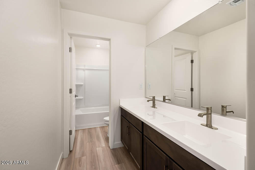 1094 Feliz Street Florence, AZ 85132 - Photo 11 of 13 a bathroom with a double vanity sink a mirror and a bathtub