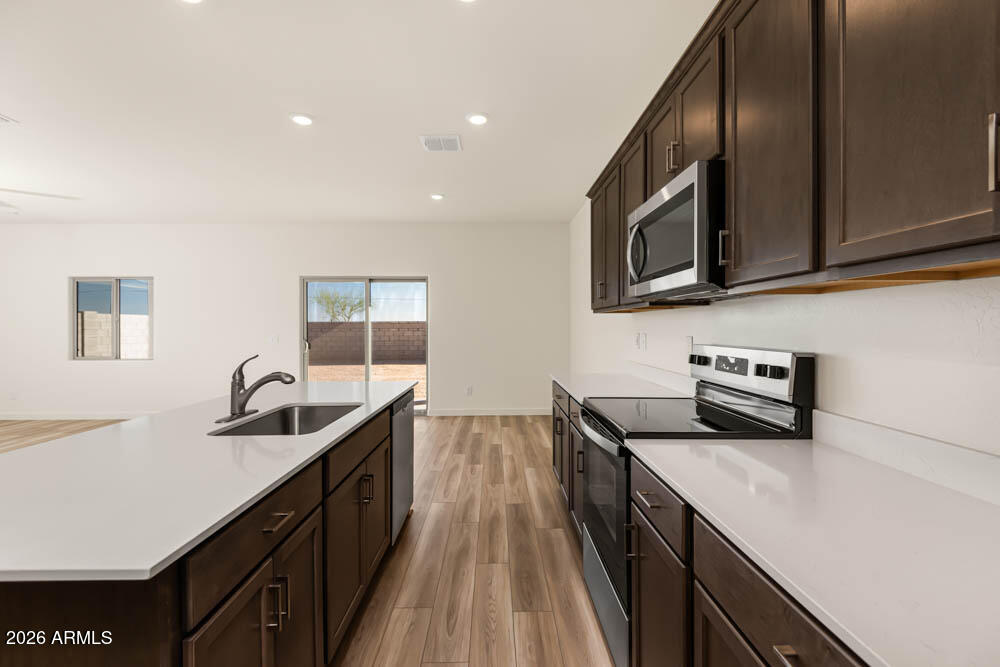 1094 Feliz Street Florence, AZ 85132 - Photo 2 of 13 a kitchen with stainless steel appliances a sink stove and microwave