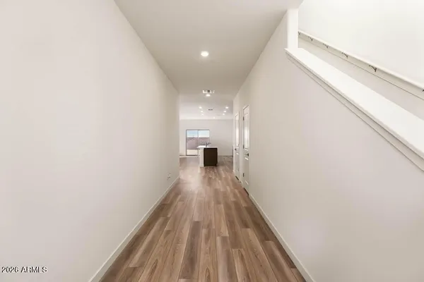 a view of a hallway with wooden floor and staircase