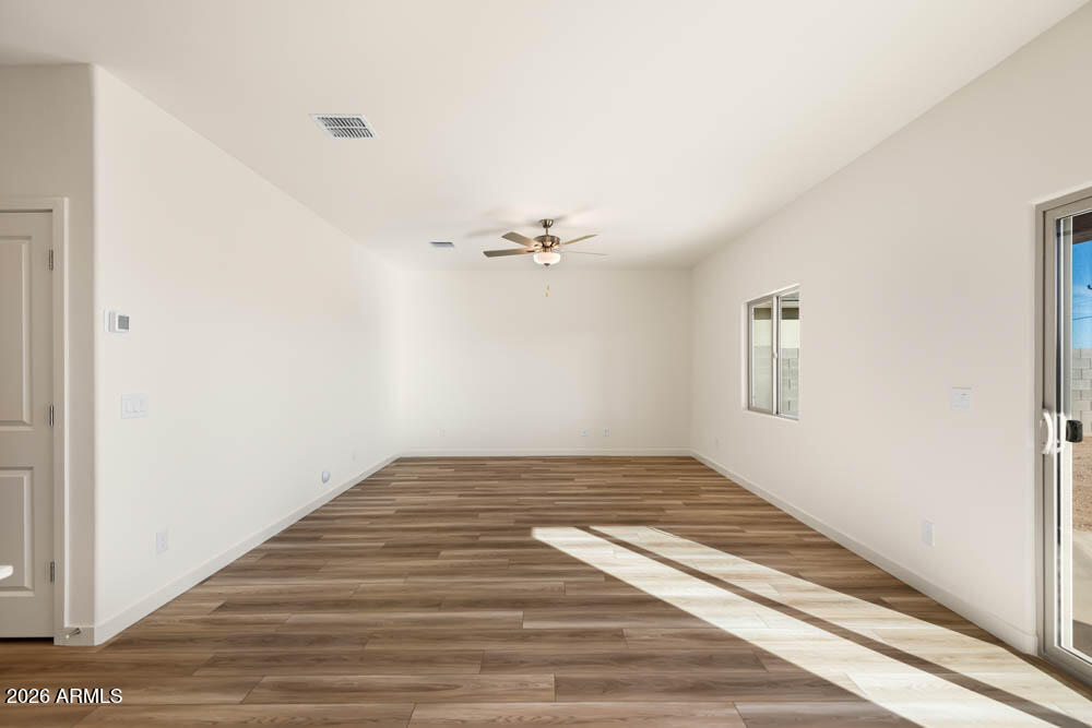 1094 Feliz Street Florence, AZ 85132 - Photo 7 of 13 a view of a room with wooden floor and white walls