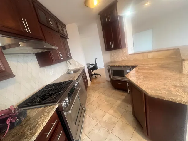 a kitchen with granite countertop a stove and a sink