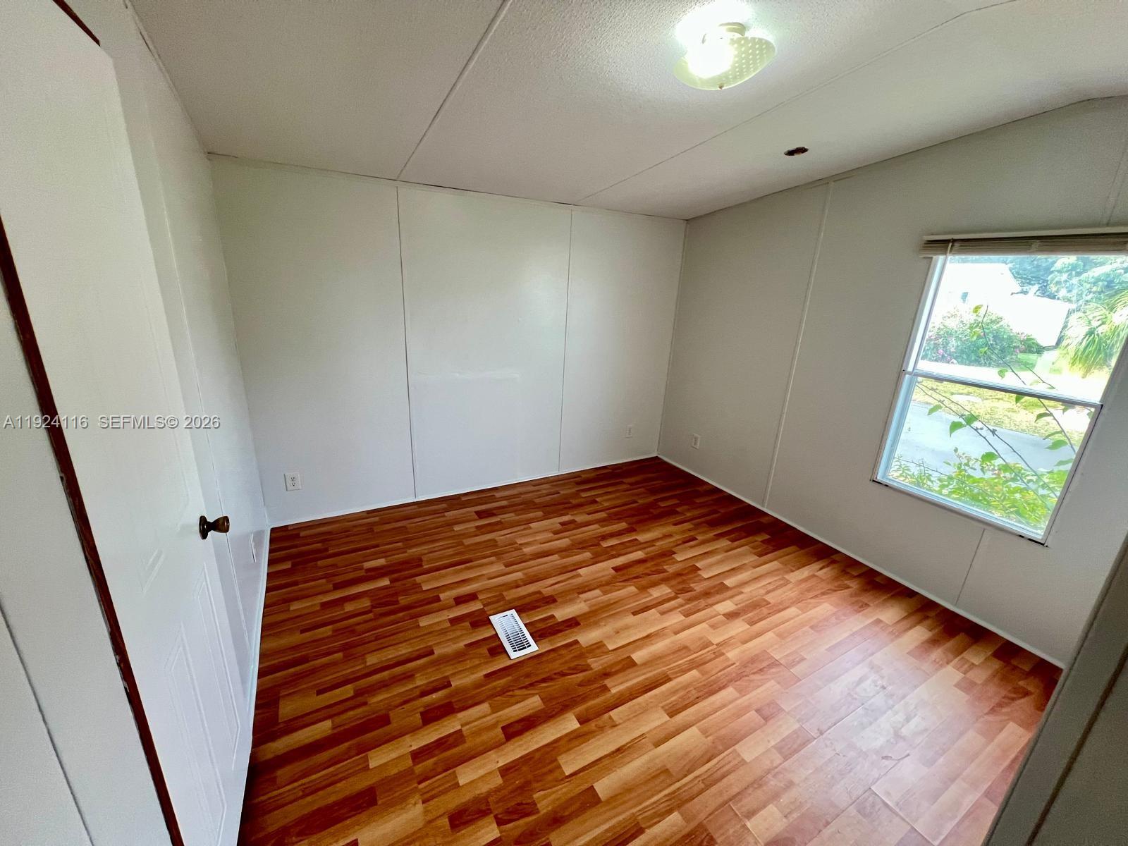 35303 Southwest 180th Avenue, Unit 399 Homestead, FL 33034 - Photo 12 of 16 a view of empty room with wooden floor and fan