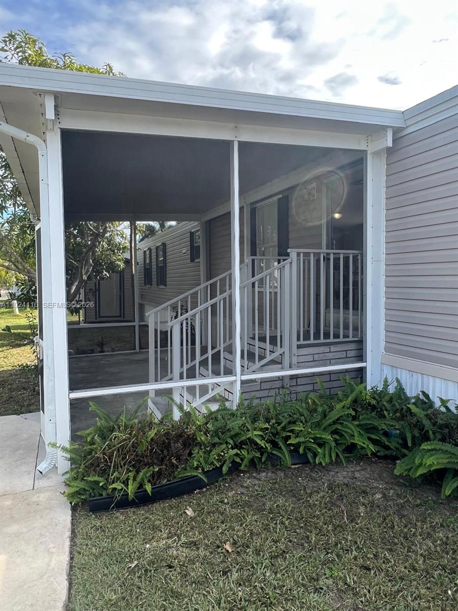 35303 Southwest 180th Avenue, Unit 399 Homestead, FL 33034 - Photo 2 of 16 a view of a house with a small yard and plants