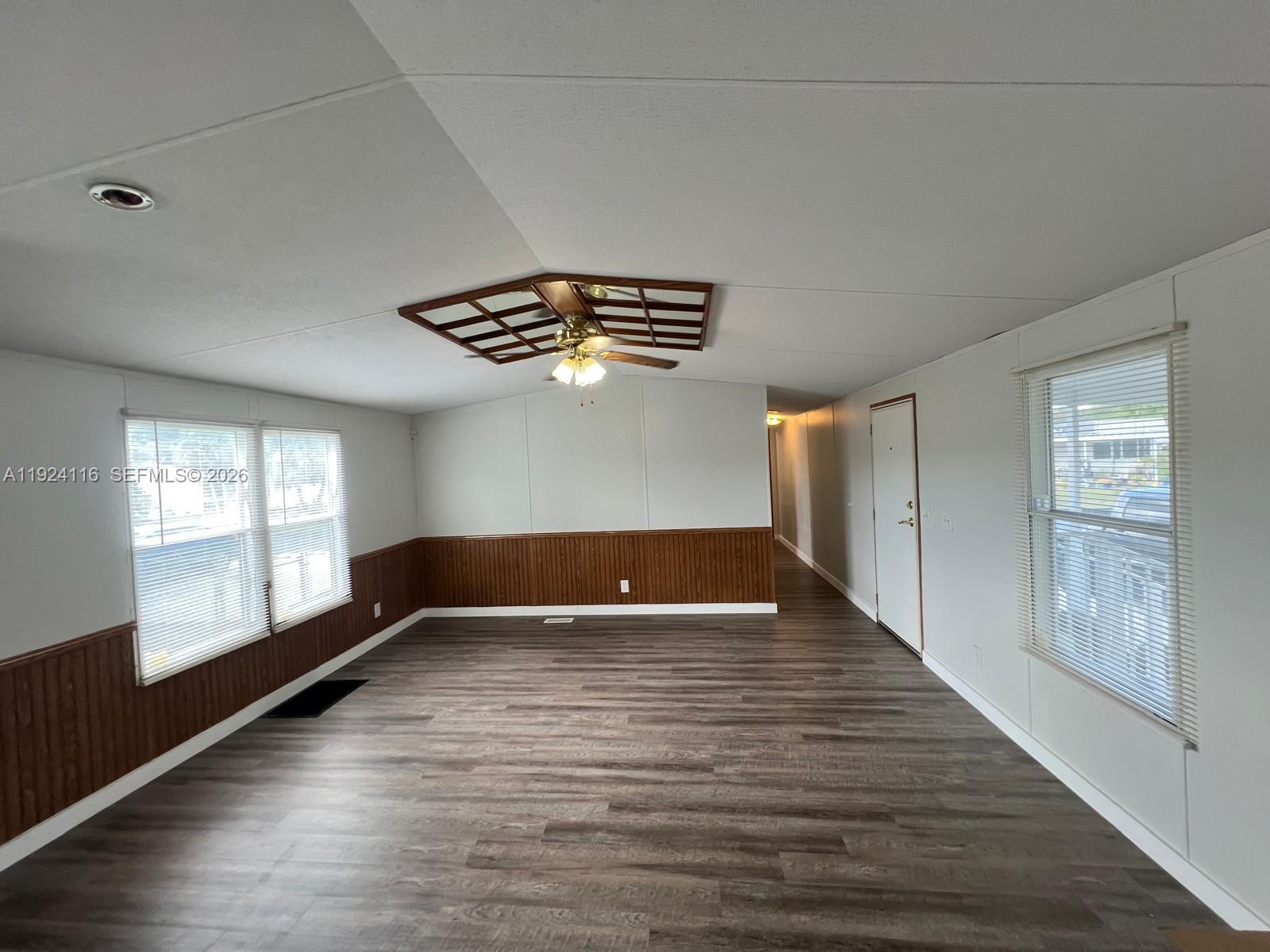 35303 Southwest 180th Avenue, Unit 399 Homestead, FL 33034 - Photo 9 of 16 a view of an empty room with wooden floor and a window