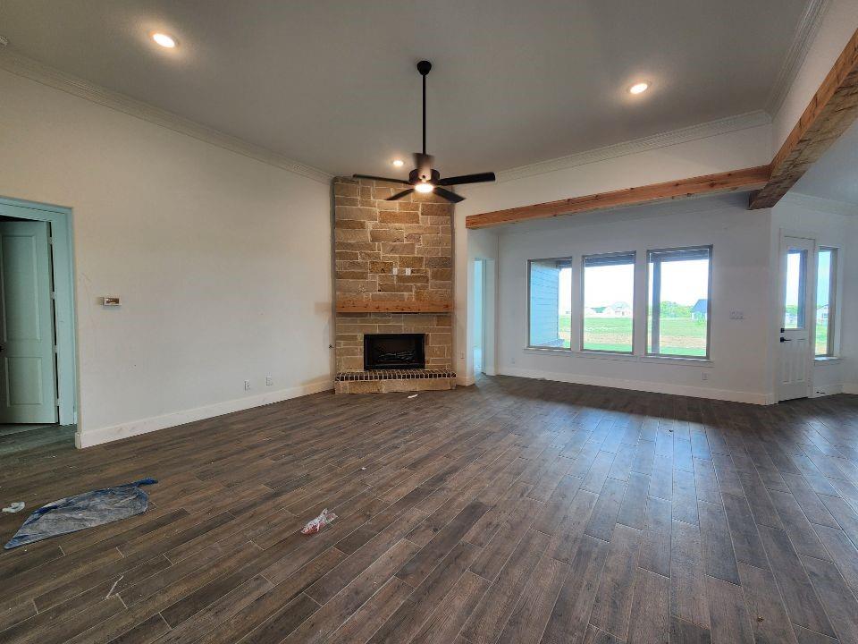 2408 Quartz Street Krum, TX 76249 - Photo 6 of 16 an empty room with wooden floor fireplace and windows