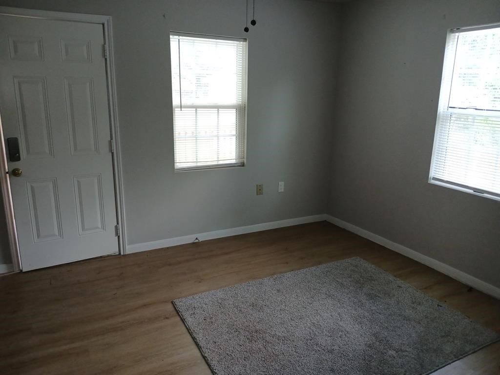 15519 Highway 6 Santa Fe, TX 77517 - Photo 13 of 14 an empty room with wooden floor and windows