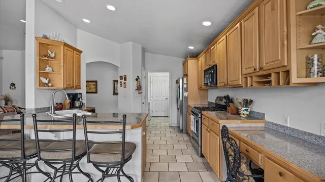 a kitchen with stainless steel appliances kitchen island granite countertop a sink and cabinets