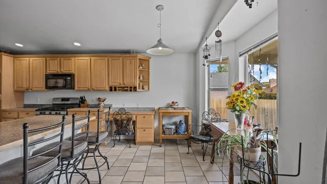 a kitchen with stainless steel appliances a table and chairs in it