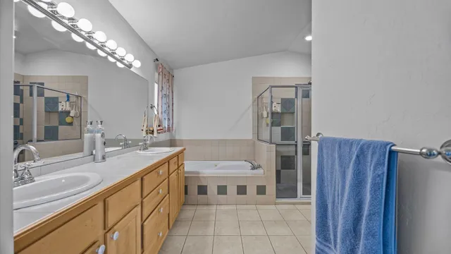 a bathroom with a sink a toilet a large mirror and shower