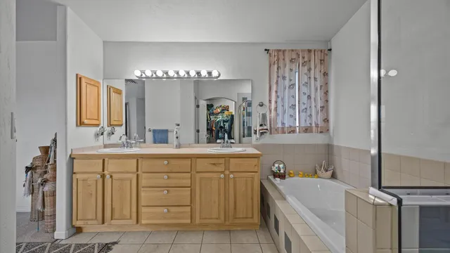 a large bathroom with a double vanity sink a mirror and a bathtub