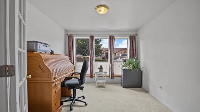 a view of a workspace with furniture and a window